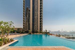 Lux BnB Dubai Creek Harbour BLVD Views في دبي: حمام سباحة كبير مع مباني طويلة في الخلفية