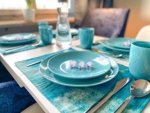 un tavolo con piatti e utensili blu sopra di Special BLUE TIGER Apartment Basel, Messe Kleinbasel 10-STAR a Basilea