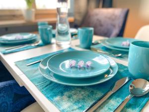 a table with blue plates and utensils on it at Special BLUE TIGER Apartment Basel, Messe Kleinbasel 10-STAR in Basel
