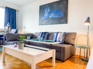 a living room with a couch and a table at Special BLUE TIGER Apartment Basel, Messe Kleinbasel 10-STAR in Basel