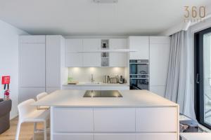 - une cuisine blanche avec des placards blancs et un évier dans l'établissement Designer 2BR home with Stunning views in St Pauls by 360 Estates, à San Pawl il-Baħar