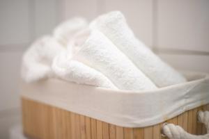 a pile of towels in a wooden basket at Special BLUE TIGER Apartment Basel, Messe Kleinbasel 10-STAR in Basel
