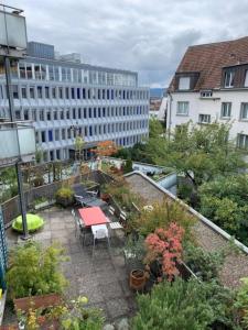 einen Balkon mit einem Tisch und Stühlen sowie ein Gebäude in der Unterkunft Sunny studio in the city center (Oken1) in Zürich