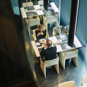 un hombre y una mujer sentados en una mesa en un restaurante en Olivia Balmes Hotel, en Barcelona