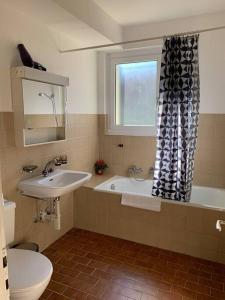 ein Badezimmer mit einem Waschbecken, einer Badewanne und einem WC in der Unterkunft Sunny studio in the city center (Oken1) in Zürich