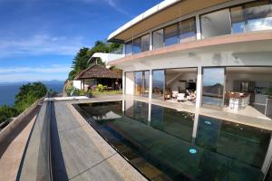 un'immagine di una casa con piscina di La Canopée vue sur mer a Nosy Be