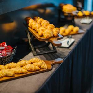 uma mesa coberta com bandejas de produtos de pastelaria em exposição em Olivia Balmes Hotel em Barcelona