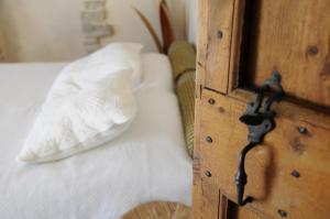eine Holztür mit einem weißen Kissen auf dem Bett in der Unterkunft Le Jas de Péguier in Châteauneuf-Val-Saint-Donat