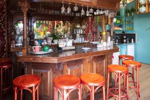 a bar with wooden stools and a counter in a room at Bloem & Bed in 't Zand