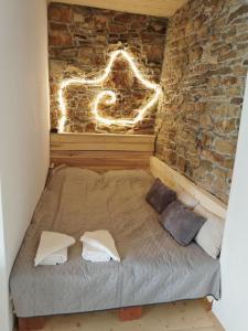 a bed in a room with a brick wall at Под шарената сянка in Kŭrpachevo