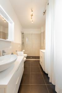 a white bathroom with two sinks and two toilets at PN3 - One bedroom flat in Florence