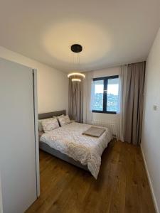 a bedroom with a bed and a large window at tbilisi garden 2 in Tbilisi City