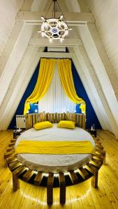 ein Schlafzimmer mit einem großen Bett mit gelben Kissen in der Unterkunft Qafqaz Mountside Chalet in Qəbələ