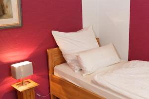 a small bed with a white pillow and a lamp at Apartment Babenhausen in Babenhausen
