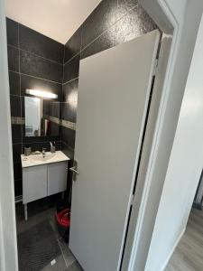 La salle de bains est pourvue d'une porte blanche et d'un lavabo. dans l'établissement Lacazavanoo, à Baillif
