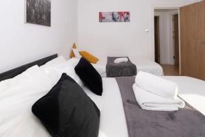a bedroom with two beds with black and white pillows at Shoreditch Apartments by DC London Rooms in London