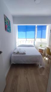 - une chambre avec un lit blanc et une grande fenêtre dans l'établissement La Reina II R&R, à Almería