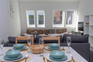 a living room with a table with plates and wine glasses at Shoreditch Apartments by DC London Rooms in London