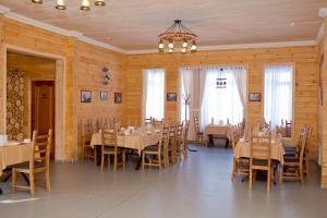 a dining room with tables and chairs and a chandelier at Ski Paradise Karakol in Karakol
