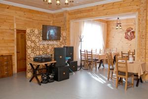 a dining room with a table and chairs and a television at Ski Paradise Karakol in Karakol