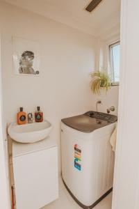 a small white bathroom with a sink and a toilet at The Sands - Convenient Location in Sydney