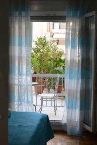 een slaapkamer met een bed en uitzicht op een balkon bij Dream apartment in Kallithea in Athene