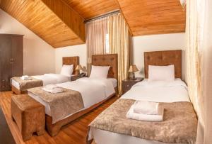 2 camas en una habitación con techos de madera en Venesa, en Tiflis