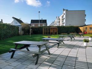 un gruppo di tavoli da picnic su un patio di Auberge La Digue a Calais