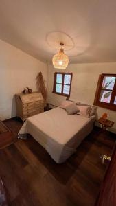 a bedroom with a large bed and a chandelier at Casa Nutabe - Casa de Campo en Girardota cerca a Medellín in Girardota