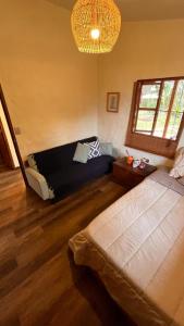 a bedroom with a bed and a couch in a room at Casa Nutabe - Casa de Campo en Girardota cerca a Medellín in Girardota