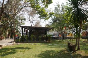 um pavilhão num parque com árvores e relva em Maewang Resort em Lampang