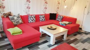 a red couch in a living room with a table at Ferienhaus Kunterbunt in Hitzacker