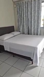 1 cama en una habitación con ventana en Suítes na Barra da Lagoa, en Florianópolis