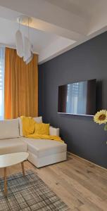 a living room with a white couch and a tv at Apartament Pod 12 in Bielsko-Biala