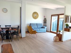 uma sala de estar com um sofá azul e uma mesa em A PINTEGA DAS DUNAS em Ribeira