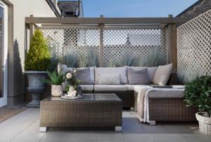 un patio con sofá y mesa en Shrubbery Mews Luxury Apartment en Kenmare