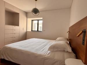 a bedroom with a large white bed and a window at Casa Sao Bento in Arcos de Valdevez