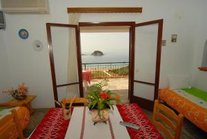 a room with a table and a room with a view of the ocean at Villa Matina Skiathos in Troulos +8 photos