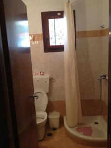 a bathroom with a toilet and a window and a shower at Villa Matina Skiathos in Troulos