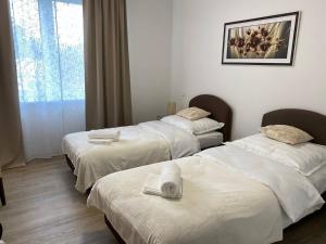 a hotel room with three beds with towels on them at Perla Hradce 303 in Hradec Králové +28 photos