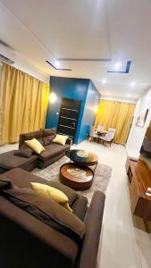 a living room with two couches and a table at Appartement Luxueux de 3 pièces - Cotonou in Cotonou