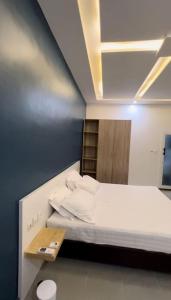 a small room with a bed and a shelf at Appartement Luxueux de 3 pièces - Cotonou in Cotonou