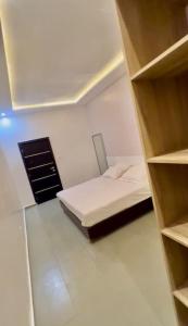 Habitación pequeña con cama y armario en Appartement Luxueux de 3 pièces - Cotonou, en Cotonou
