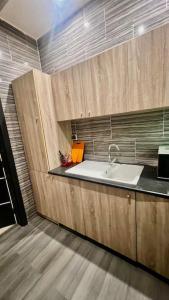 una cocina con fregadero y armarios de madera en Appartement Luxueux de 3 pièces - Cotonou, en Cotonou