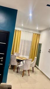 a dining room with a table and chairs and a window at Appartement Luxueux de 3 pièces - Cotonou in Cotonou