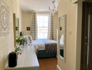 1 dormitorio con cama y espejo grande en The Wadham, en Weymouth