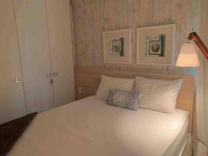 - une chambre avec un lit blanc et 2 oreillers dans l'établissement Aquiraz Riviera - Manhattan Beach Riviera - Bangalô Térreo, à Aquiraz