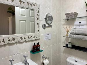 ein Bad mit einem Waschbecken und einem Spiegel in der Unterkunft The Wadham in Weymouth