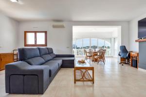 Villas Guzman - Alex في بينيسا: غرفة معيشة مع أريكة زرقاء وطاولة