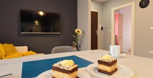 dos trozos de pastel sentados en una mesa en Apartament Pod 12, en Bielsko-Biala